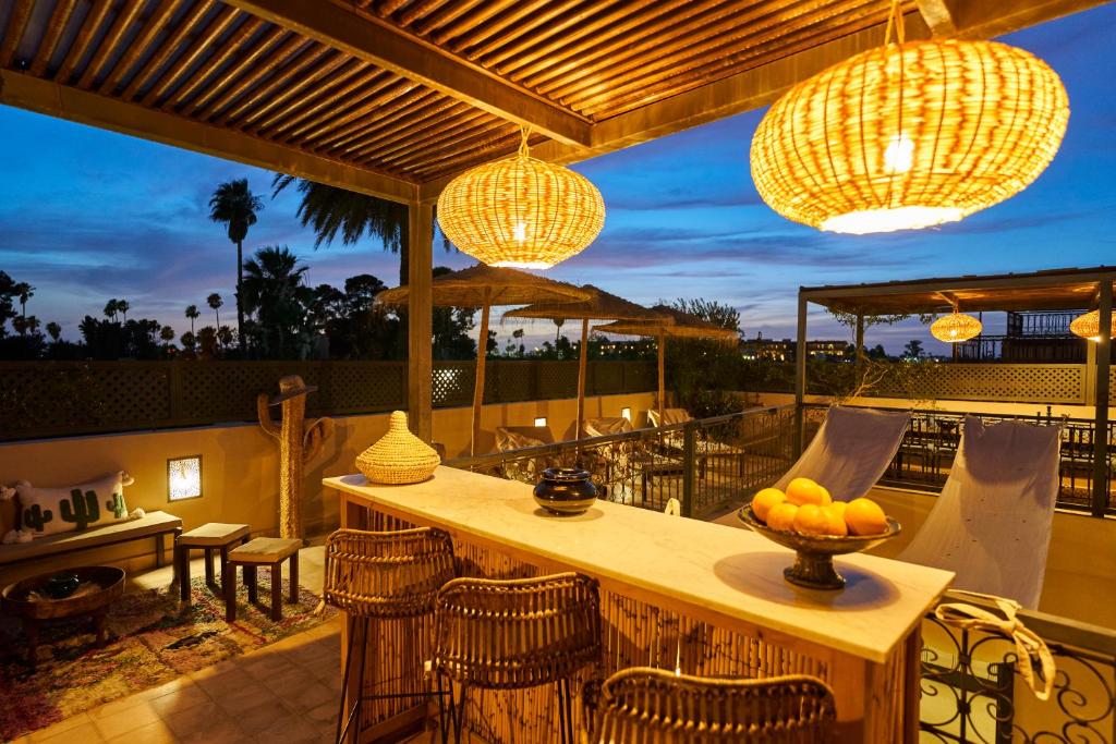d'une terrasse avec un bar, des chaises et des lumières. dans l'établissement Riad Algora en exclusivité 13 P au cœur de la Médina, à Marrakech