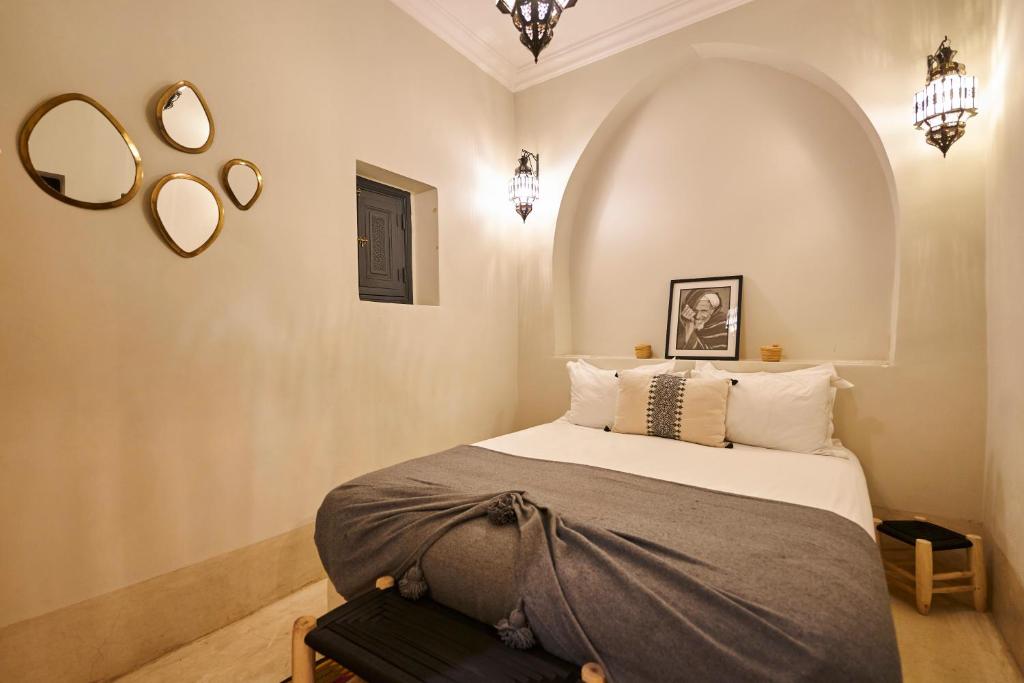 une chambre avec un lit et deux miroirs au mur dans l'établissement Riad Algora en exclusivité 13 P au cœur de la Médina, à Marrakech 39 autres photos