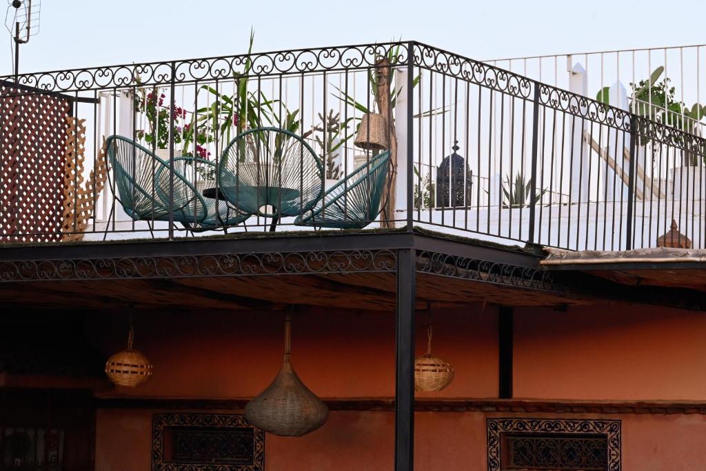 - un balcon avec des plantes en pot au-dessus d'un bâtiment dans l'établissement La Casa Ysabella, à Marrakech