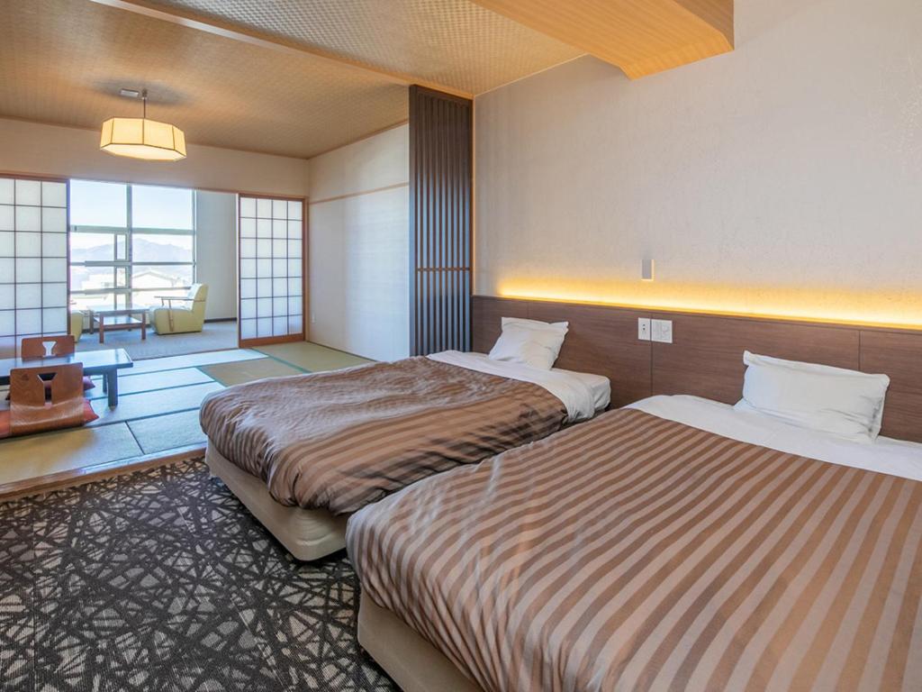une chambre d'hôtel avec deux lits dans une chambre dans l'établissement Kindayu, à Shibukawa 27 autres photos