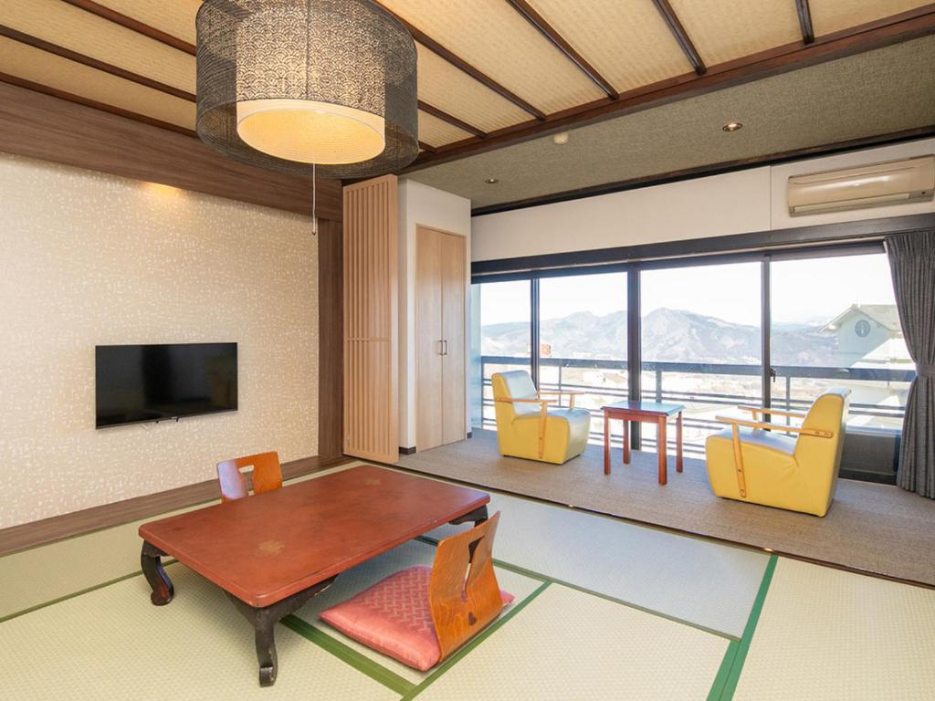 un salon avec une table et des chaises jaunes dans l'établissement Kindayu, à Shibukawa