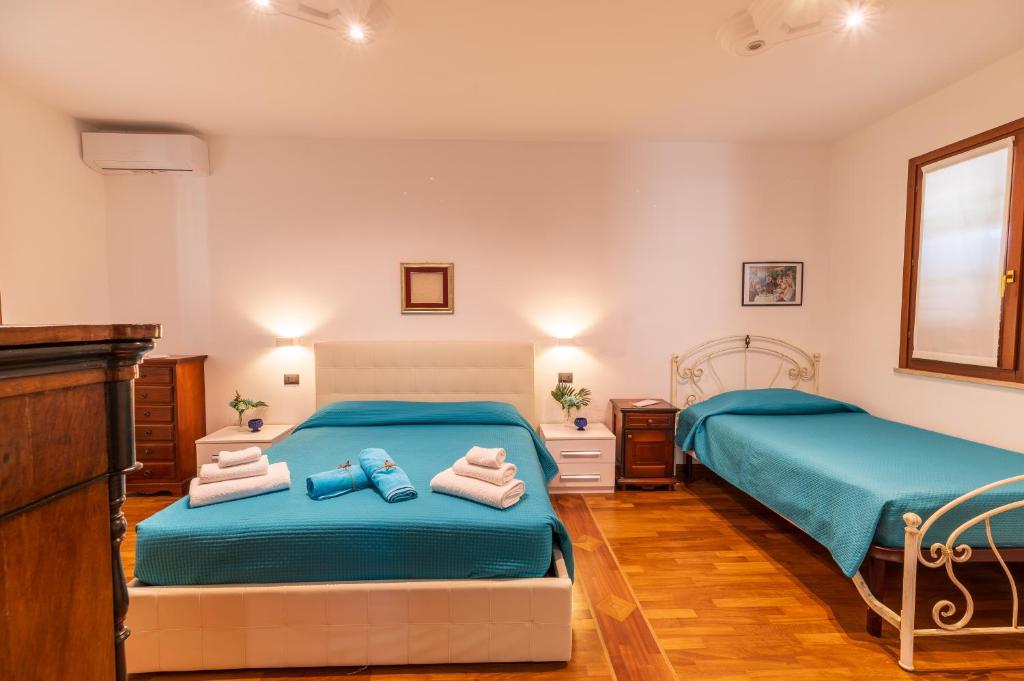 deux lits dans une petite pièce avec serviettes et jouets dans l'établissement Aqua Suites Doria, à Syracuse