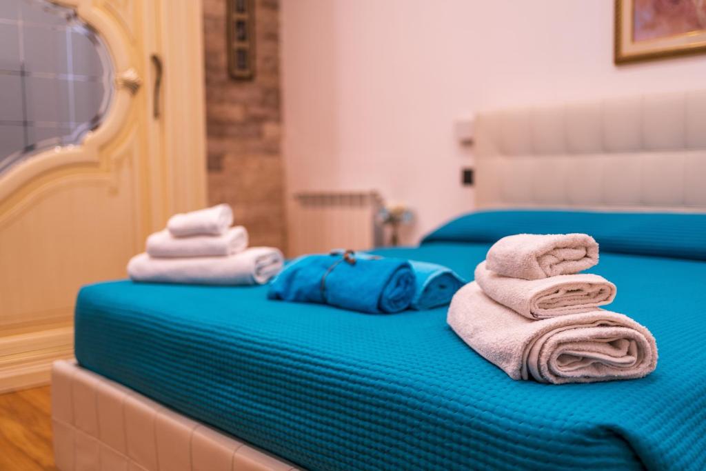 - 2 lits avec des serviettes assises au-dessus dans l'établissement Aqua Suites Doria, à Syracuse