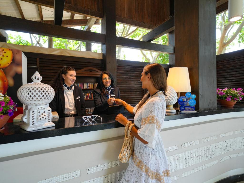 une femme debout devant un bar avec deux femmes dans l'établissement Le Dune Resort, à Menfi 33 autres photos