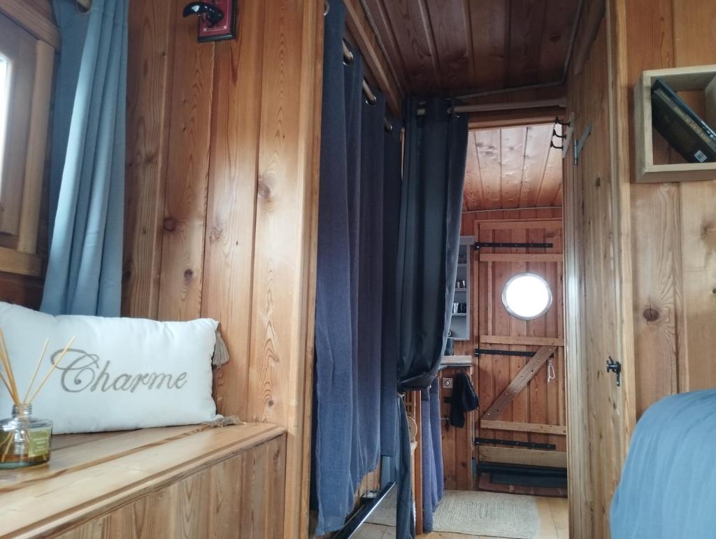 - une chambre dotée de murs en bois et d'un lit avec un oreiller dans l'établissement La Toue Charme, à Angers