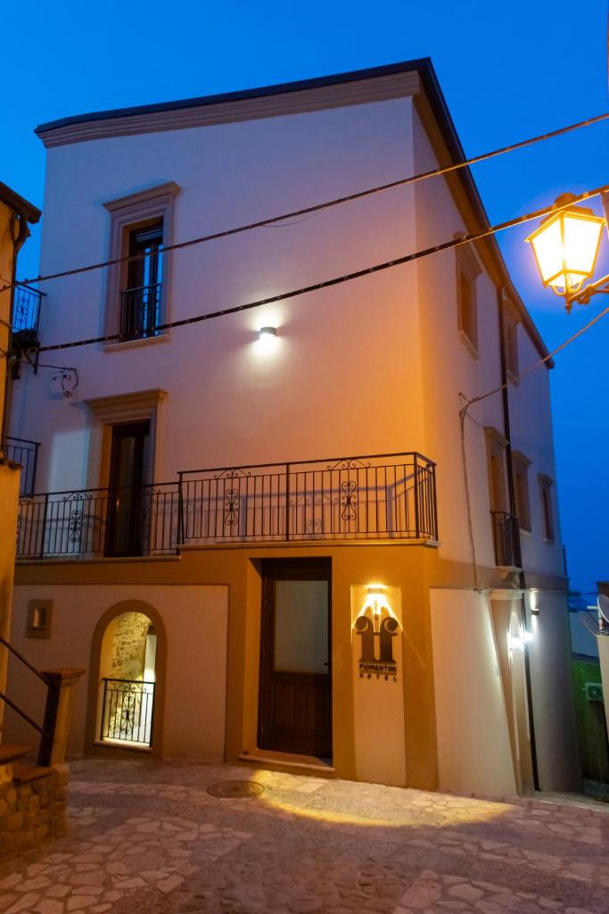 Un grand bâtiment blanc avec balcon est disponible la nuit. dans l'établissement Palazzo Fiorentini Charme Hotel, à Cariati 63 autres photos