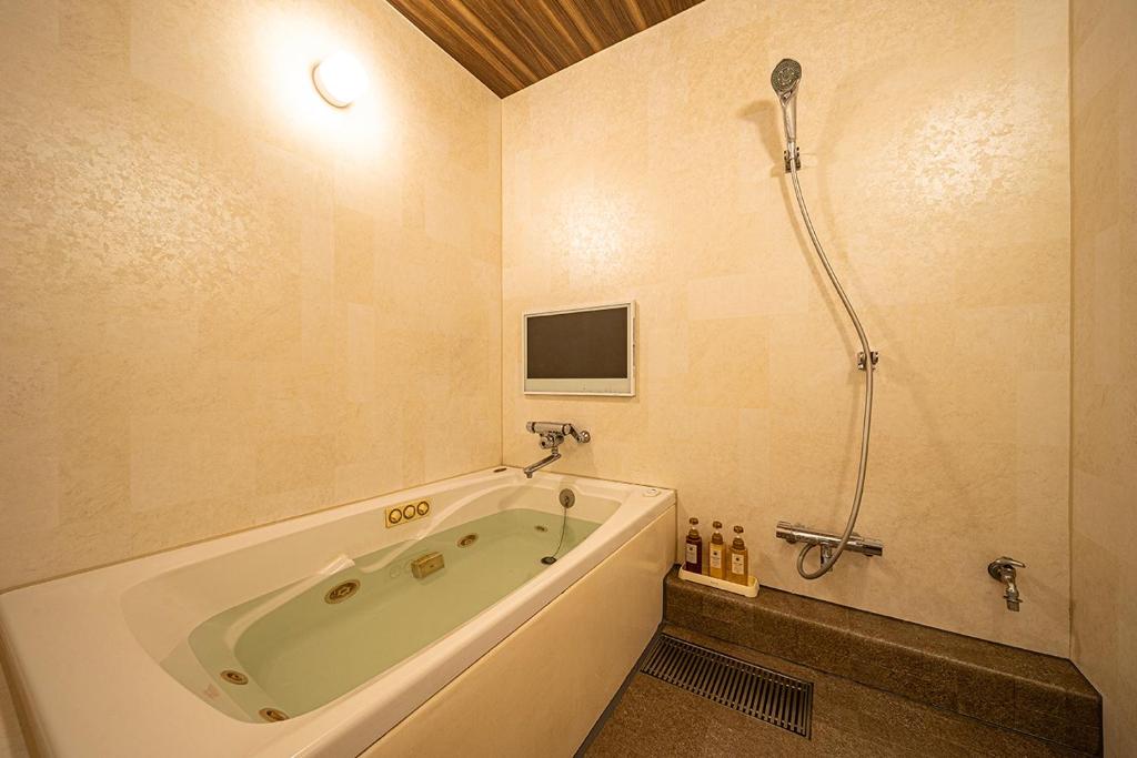 une salle de bain avec baignoire et douche dans l'établissement HOTEL FIVE plus -Adult Only-, à Osaka