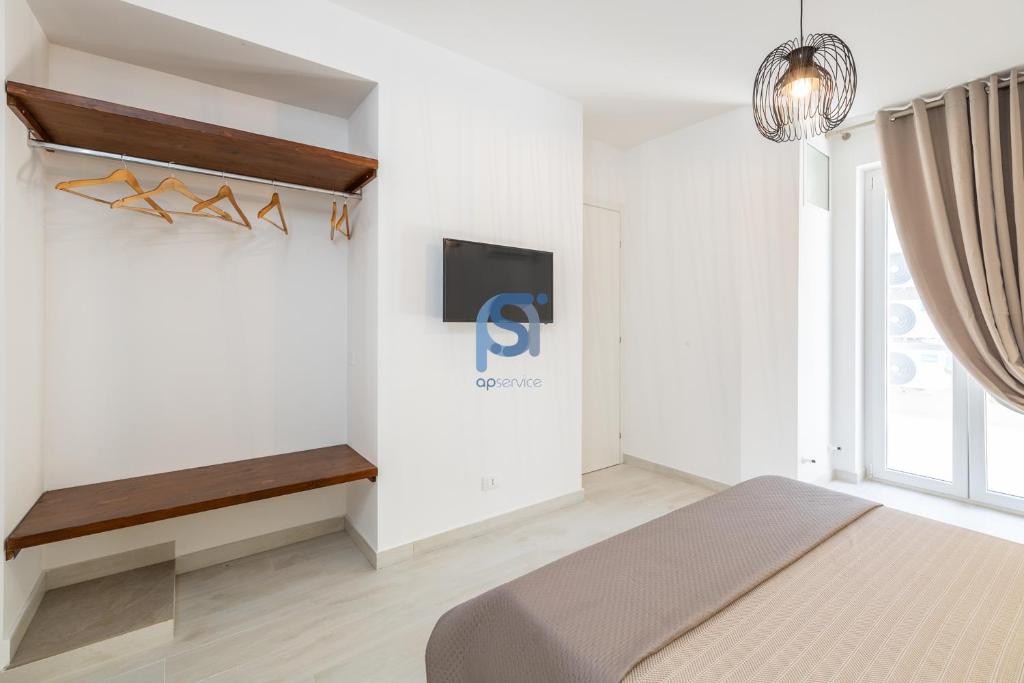 une chambre avec un lit et une télévision sur un mur dans l'établissement Villa Irene Deluxe, à Campofelice di Roccella