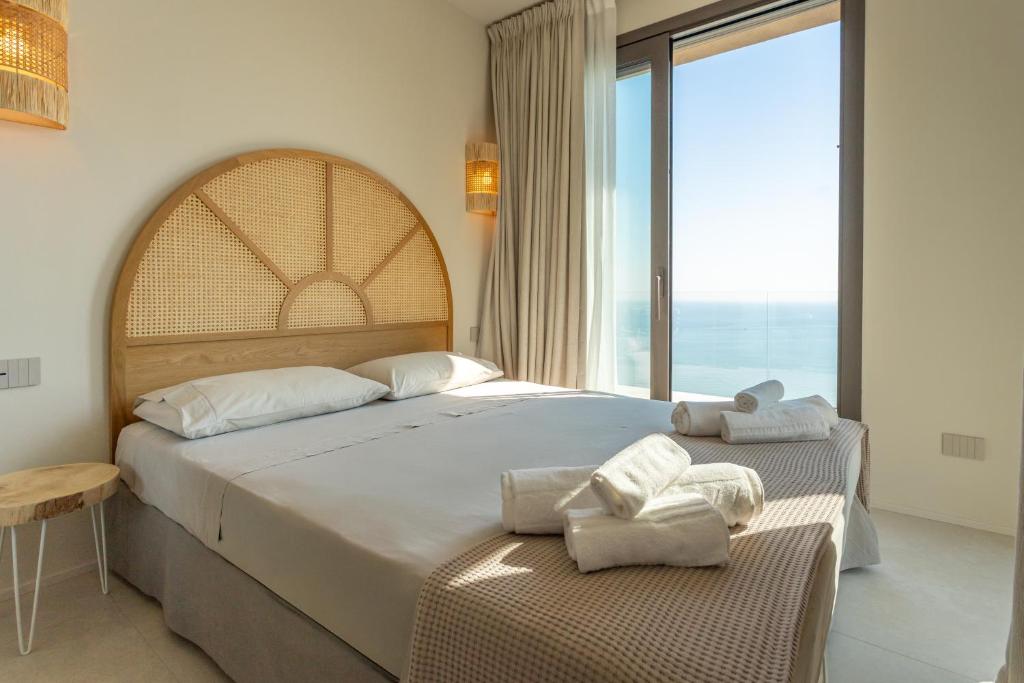 une chambre avec un grand lit et une grande fenêtre dans l'établissement Terrazza Incanti, à Fiorenzuola di Focara