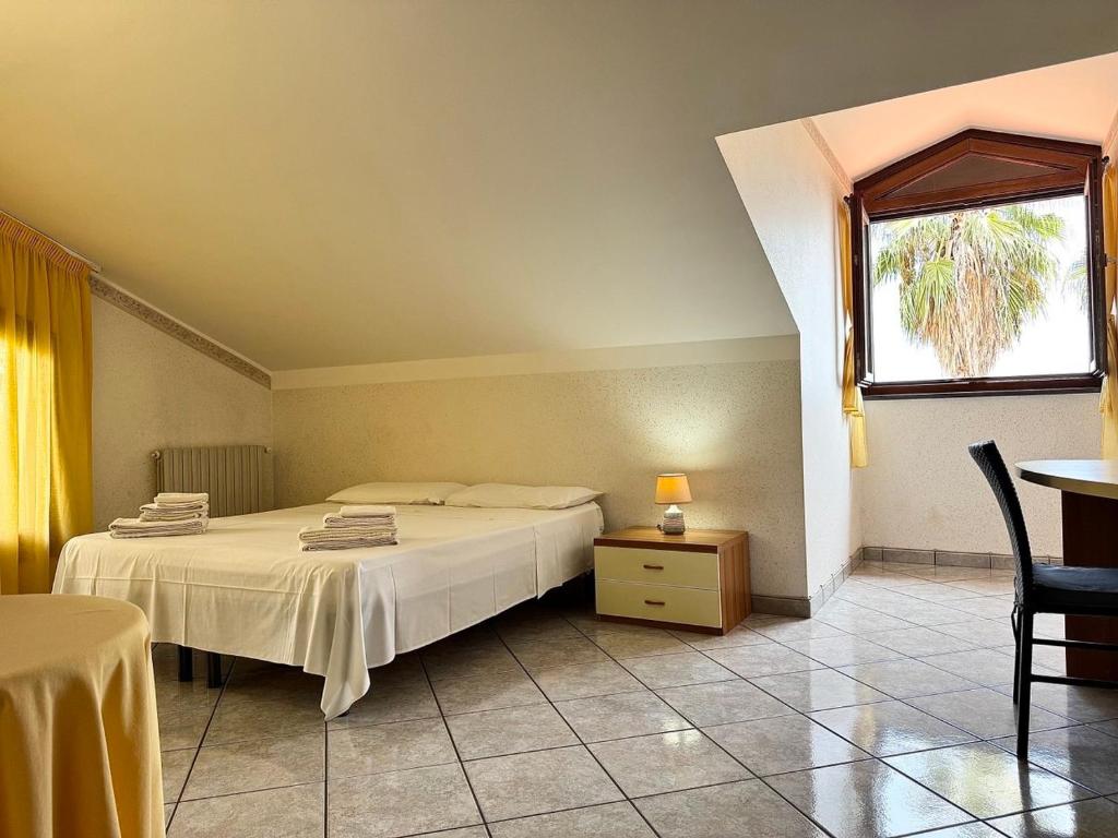 une chambre avec un lit, une fenêtre et une table dans l'établissement Villa esclusiva con piscina privata e vista Etna, à Zafferana Etnea