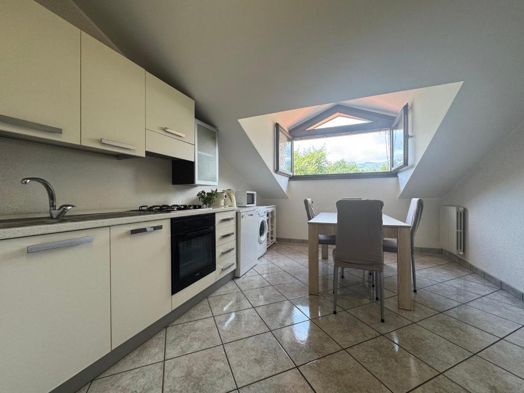 une cuisine avec une table, un évier et une fenêtre dans l'établissement Villa esclusiva con piscina privata e vista Etna, à Zafferana Etnea