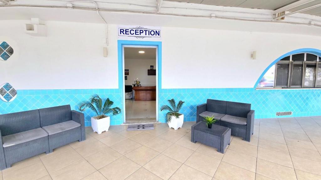 un hall d'entrée avec deux canapés et un panneau indiquant réception dans l'établissement Hotel paradiso, à Scalea