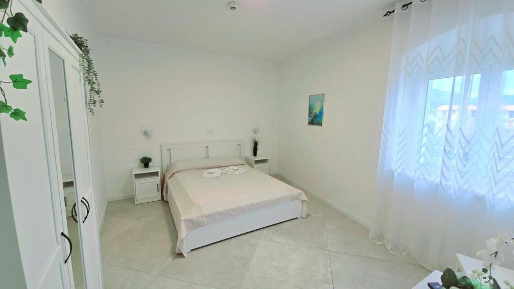 une chambre blanche avec un lit et une fenêtre dans l'établissement Hotel paradiso, à Scalea