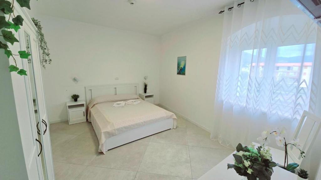 une chambre blanche avec un lit et une fenêtre dans l'établissement Hotel paradiso, à Scalea