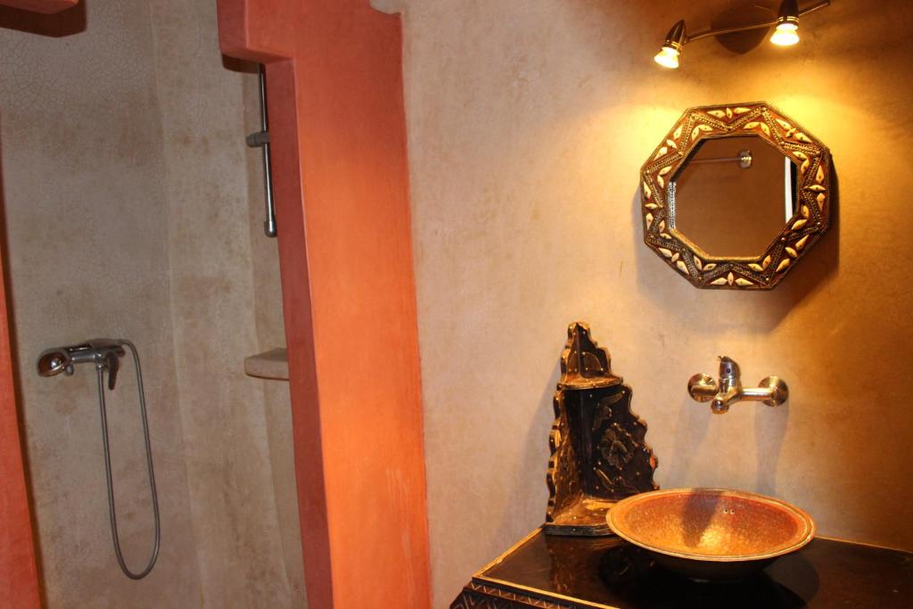 une salle de bain avec un lavabo et un miroir au mur dans l'établissement Riad Salmiya Dune, à Essaouira