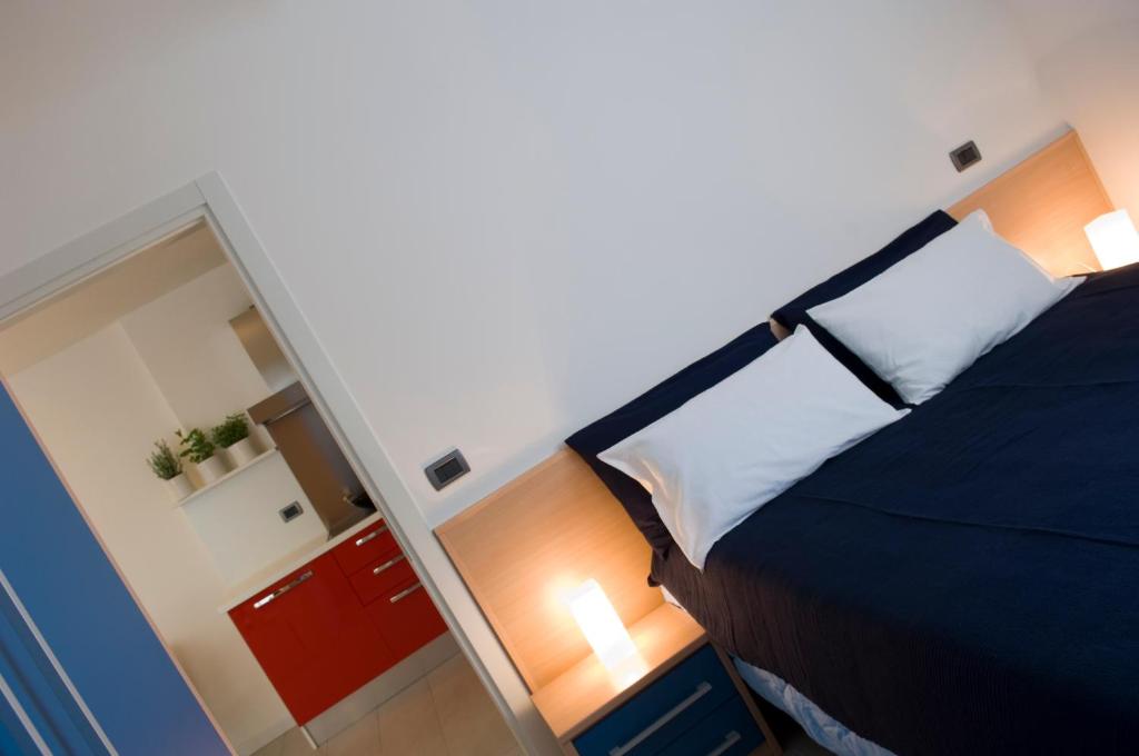 une petite chambre avec un lit et un miroir dans l'établissement Residence Hotel Hungaria, à Grado