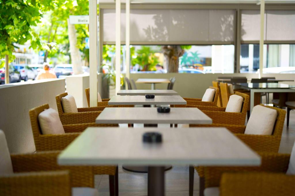 une rangée de tables et de chaises dans un restaurant dans l'établissement Hotel Sant'Elena, à Rimini 98 autres photos