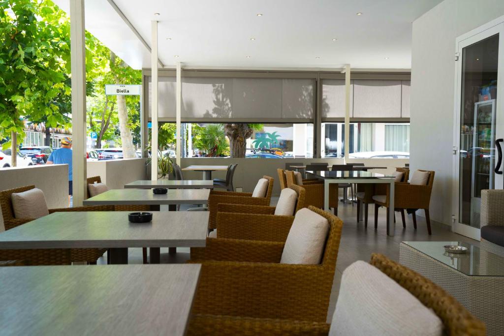 un restaurant avec des tables, des chaises, des tables et des chaises dans l'établissement Hotel Sant'Elena, à Rimini