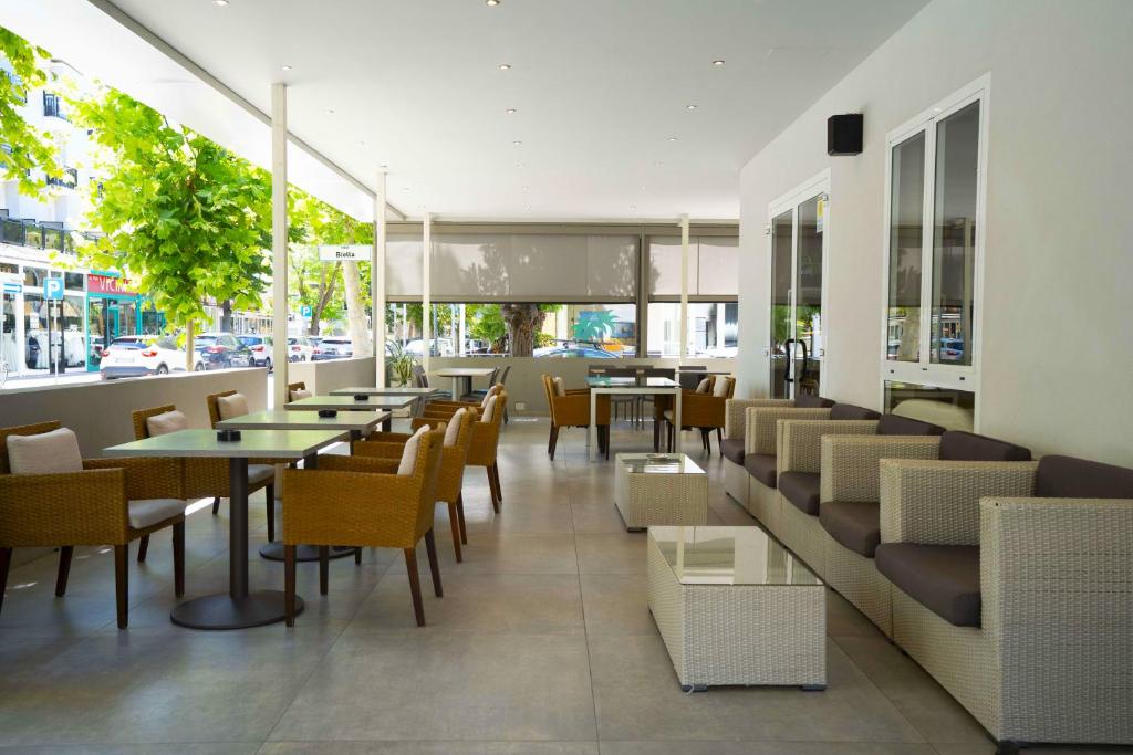 un restaurant avec des tables et des chaises et une rue dans l'établissement Hotel Sant'Elena, à Rimini