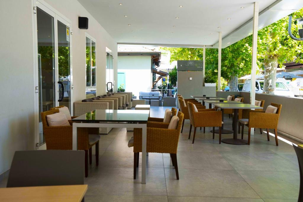 un restaurant avec des tables, des chaises et des fenêtres dans l'établissement Hotel Sant'Elena, à Rimini