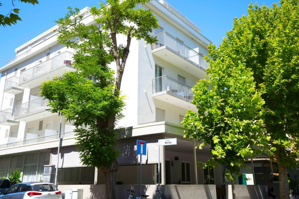 un bâtiment blanc avec des arbres devant dans l'établissement Hotel Sant'Elena, à Rimini