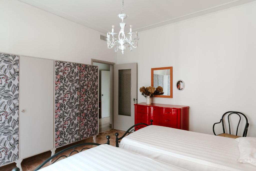 - une chambre avec 2 lits et une armoire rouge dans l'établissement Casa Piero, relax e piscina privata tra le colline delle Langhe, à Alba