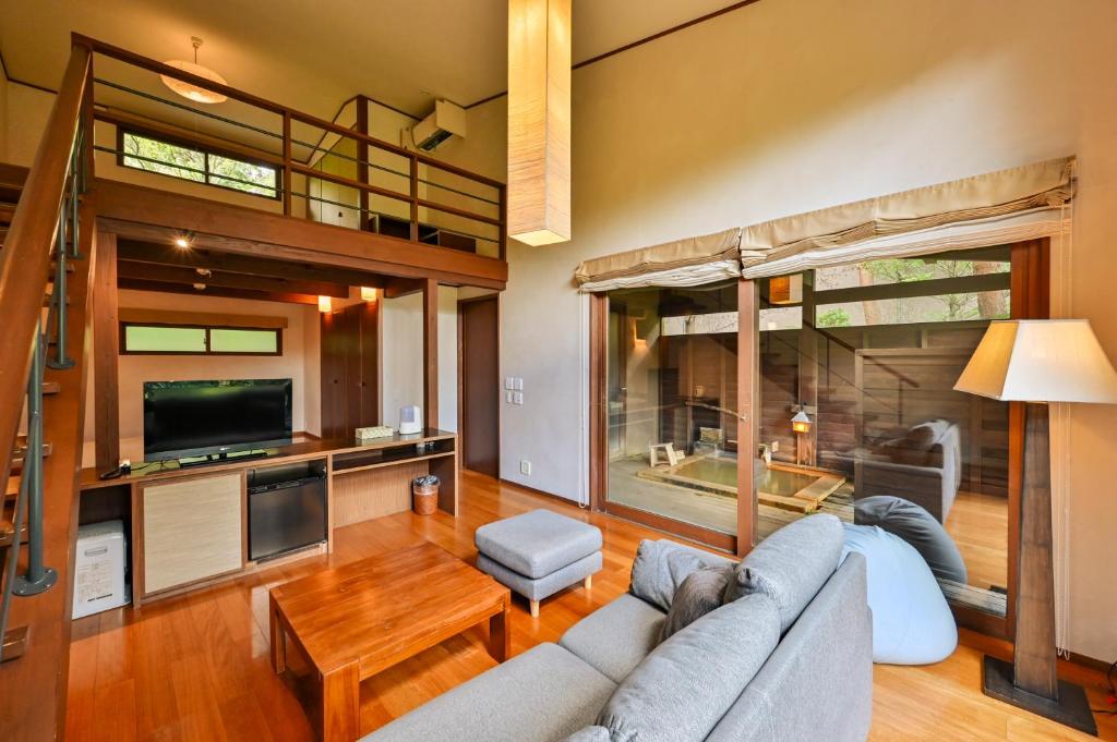 un salon avec un canapé et une télévision dans l'établissement Oita Kuoritei, à Kokonoe