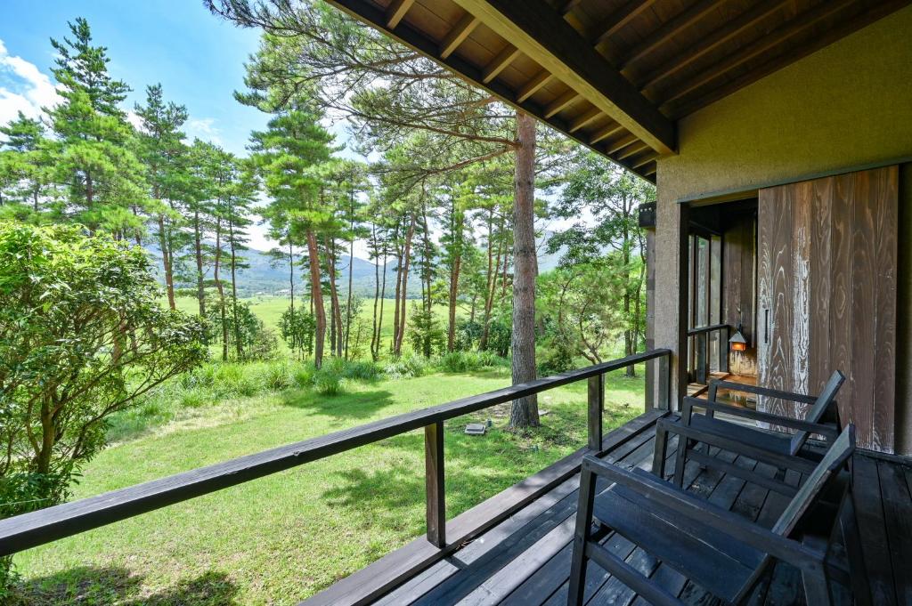 un balcon avec vue sur les bois dans l'établissement Oita Kuoritei, à Kokonoe