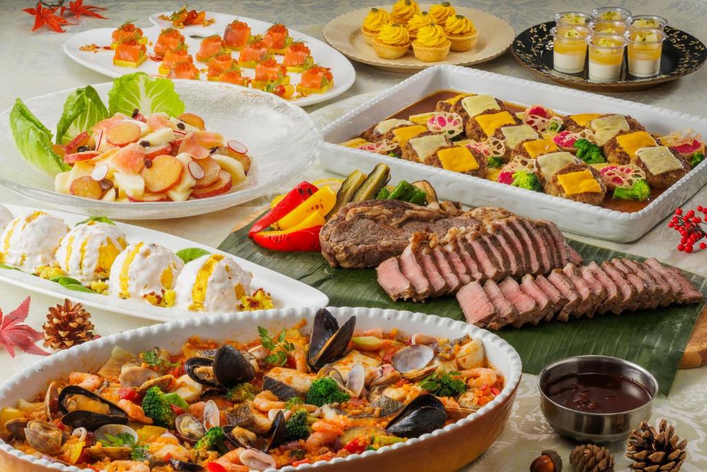 une table avec de nombreuses assiettes de nourriture différentes dans l'établissement Spa Resort Hawaiians VIR Port, à Iwaki