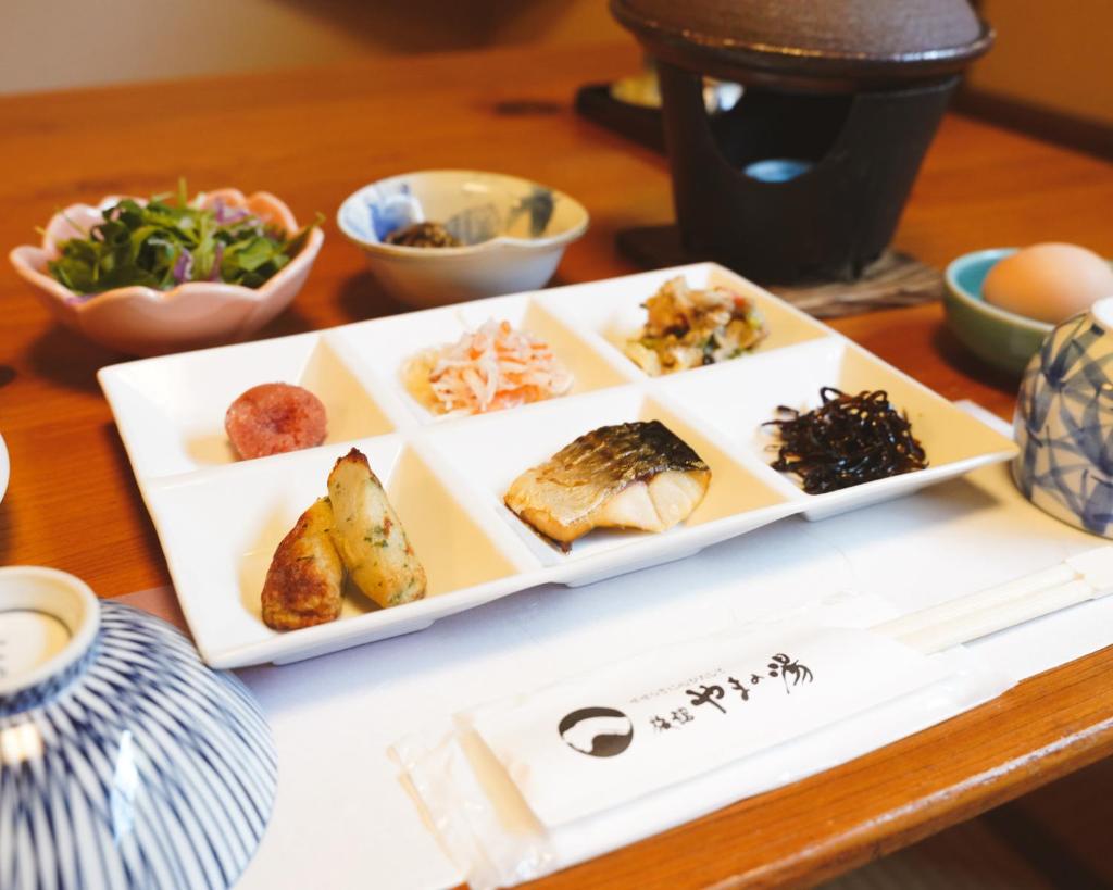 une assiette contenant différents types de denrées alimentaires sur une table dans l'établissement Ryokan Yamanoyu, à Minamioguni 29 autres photos
