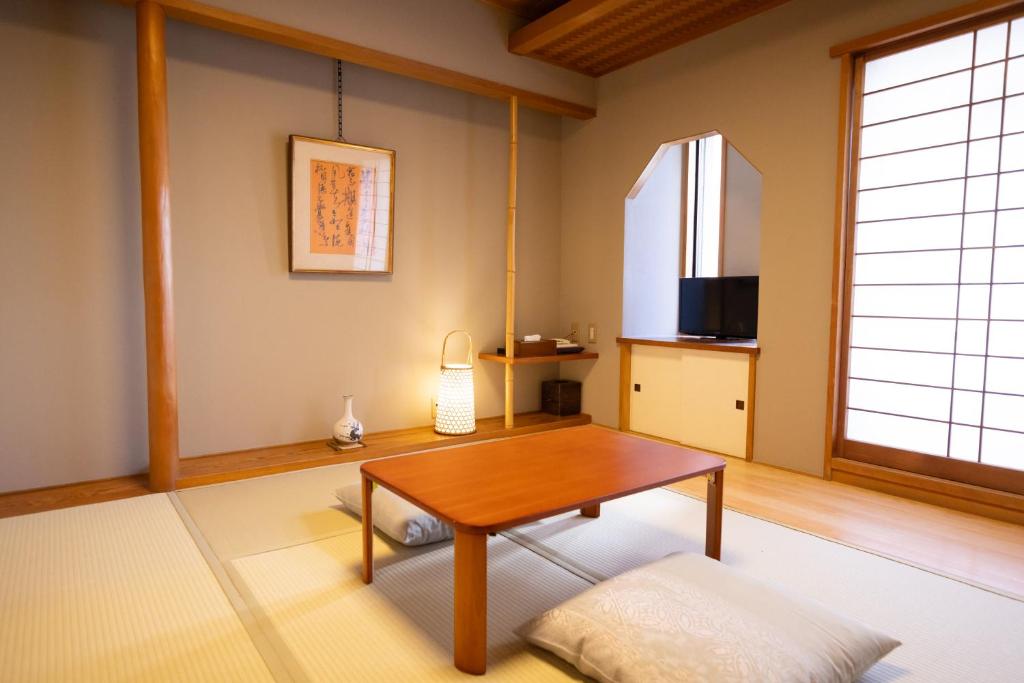 un salon avec une table et une fenêtre dans l'établissement Ryokan Asakusa Shigetsu, à Tokyo