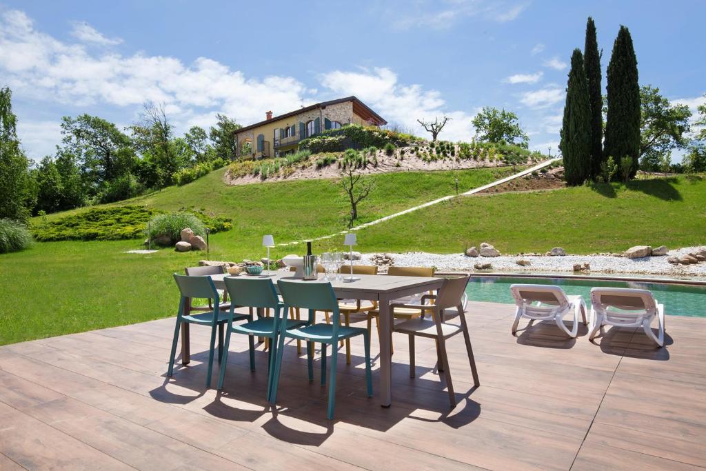 - une table et des chaises sur une terrasse à côté de la piscine dans l'établissement Luxury Villa Monte Orione Garda, à Costermano