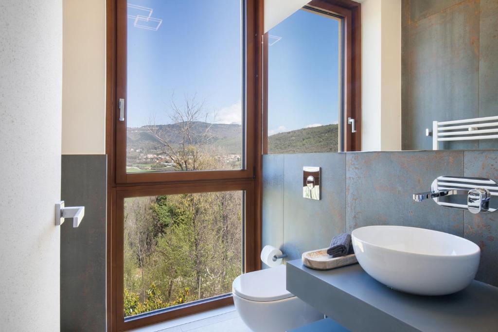 une salle de bain avec un lavabo et une grande fenêtre dans l'établissement Luxury Villa Monte Orione Garda, à Costermano