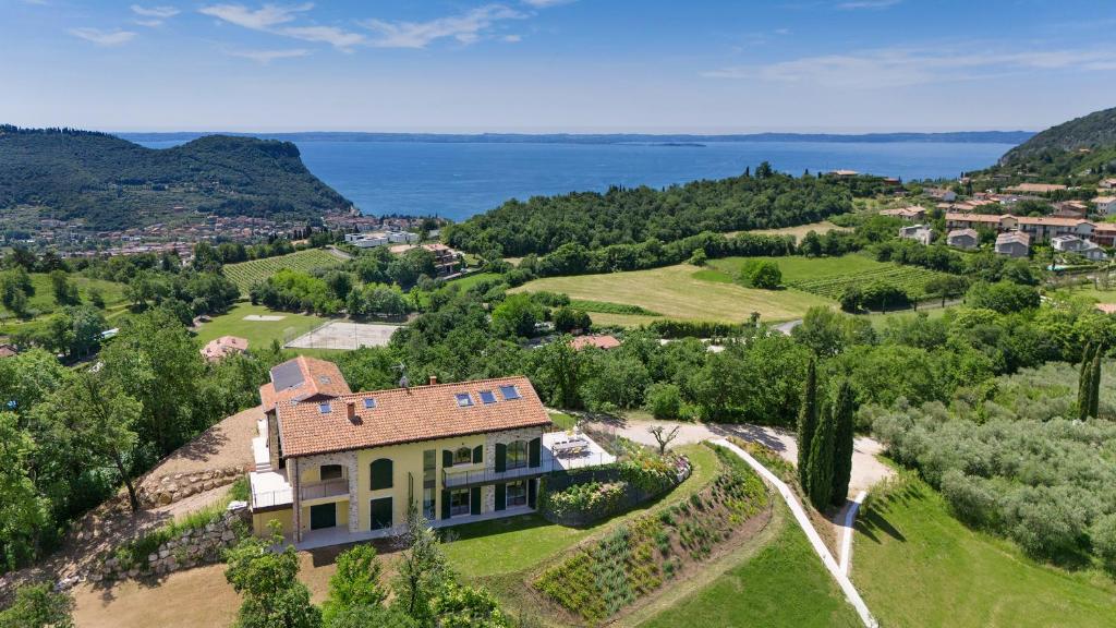 Vue aérienne d'une maison sur une colline près de l'eau dans l'établissement Luxury Villa Monte Orione Garda, à Costermano