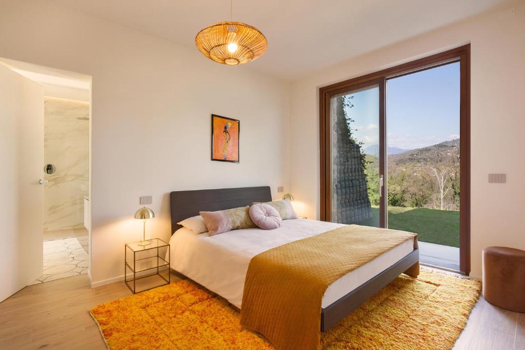 une chambre avec un lit et une grande fenêtre dans l'établissement Luxury Villa Monte Orione Garda, à Costermano
