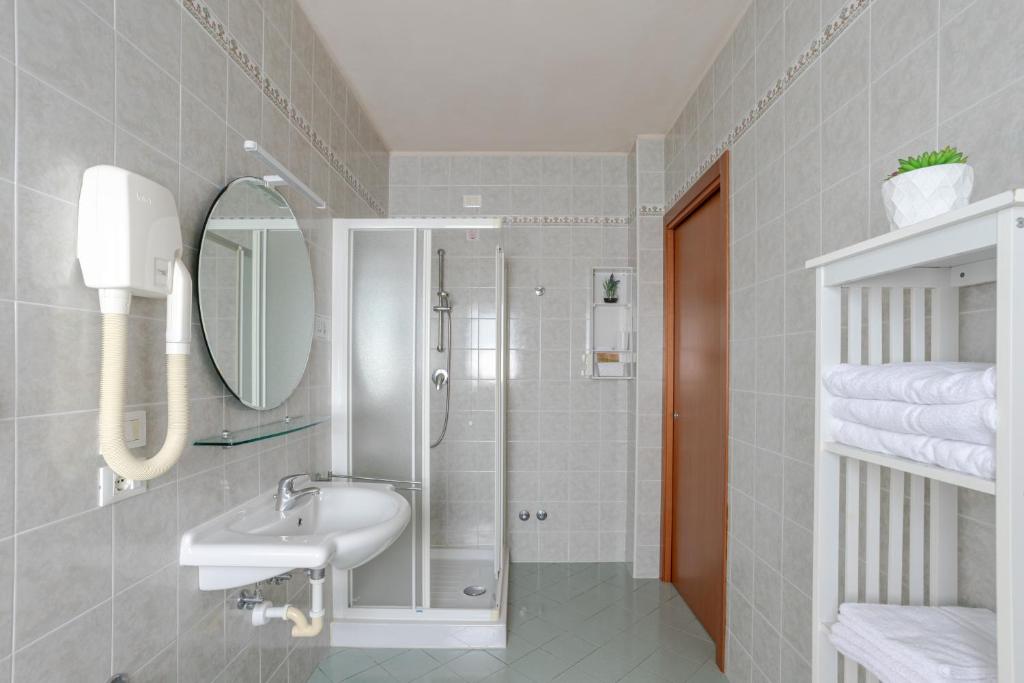 une salle de bain avec un lavabo et une douche avec un miroir dans l'établissement Hotel La Brezza frontemare, à Lido di Jesolo