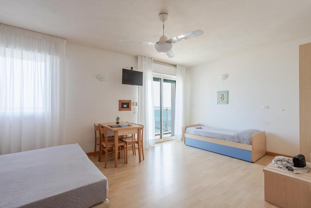 - une chambre avec un lit et une table avec un bureau dans l'établissement Hotel La Brezza frontemare, à Lido di Jesolo