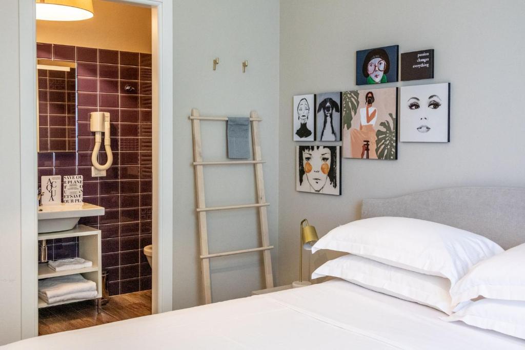 une chambre avec un lit et des tableaux au mur dans l'établissement Lu. b&b, à Cervia