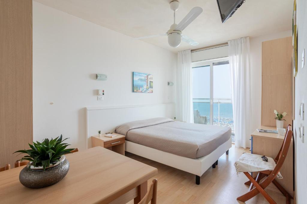 une chambre avec un lit, une table et une fenêtre dans l'établissement Hotel La Brezza frontemare, à Lido di Jesolo