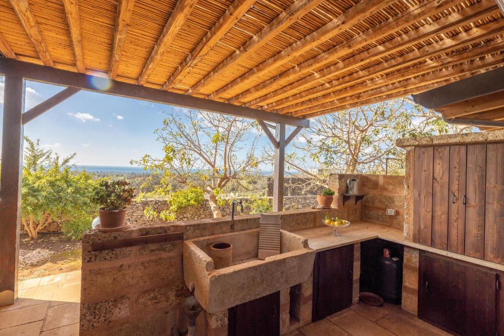 une cuisine extérieure avec une pergola en bois dans l'établissement Trullo la Ficarigna, à Alliste 44 autres photos