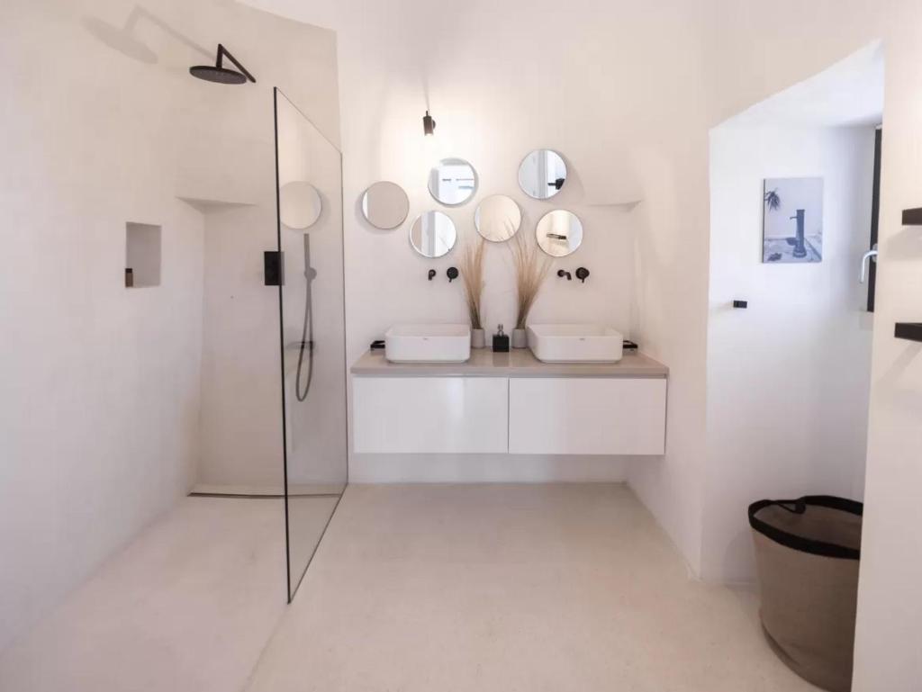 La salle de bains est pourvue de 2 lavabos et d'une douche avec miroirs. dans l'établissement Villa Monika - Luxury Trulli Resort, à Locorotondo