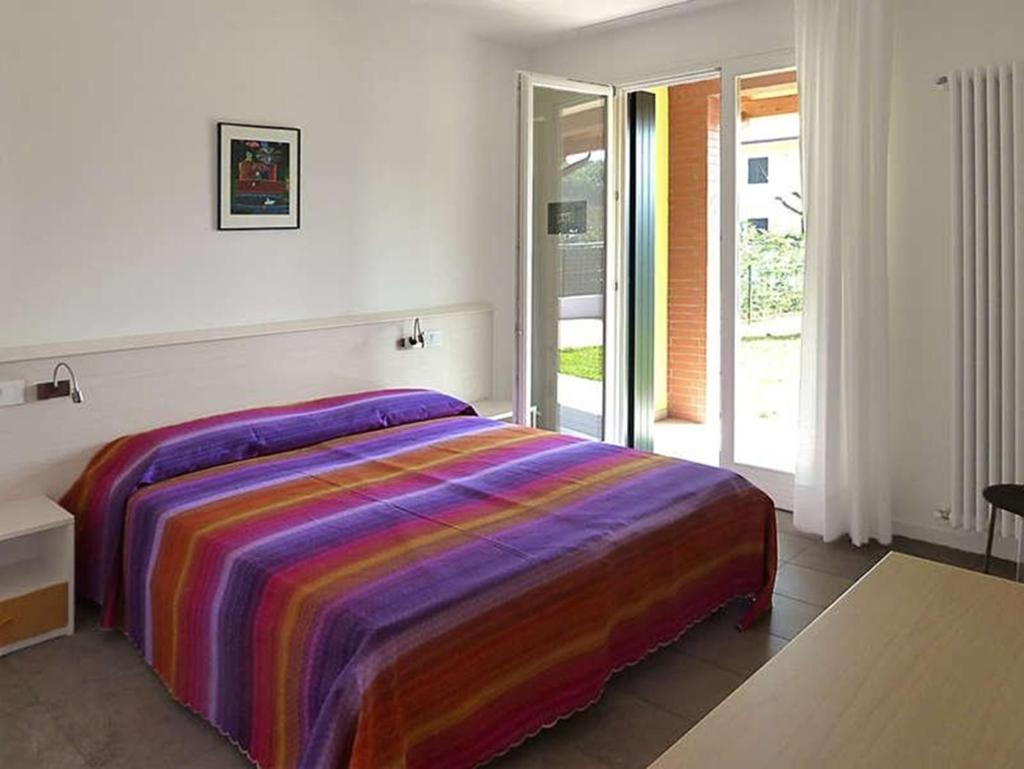 - une chambre avec un lit et une couverture colorée dans l'établissement Villa Faro Vecchio, à Cavallino-Treporti