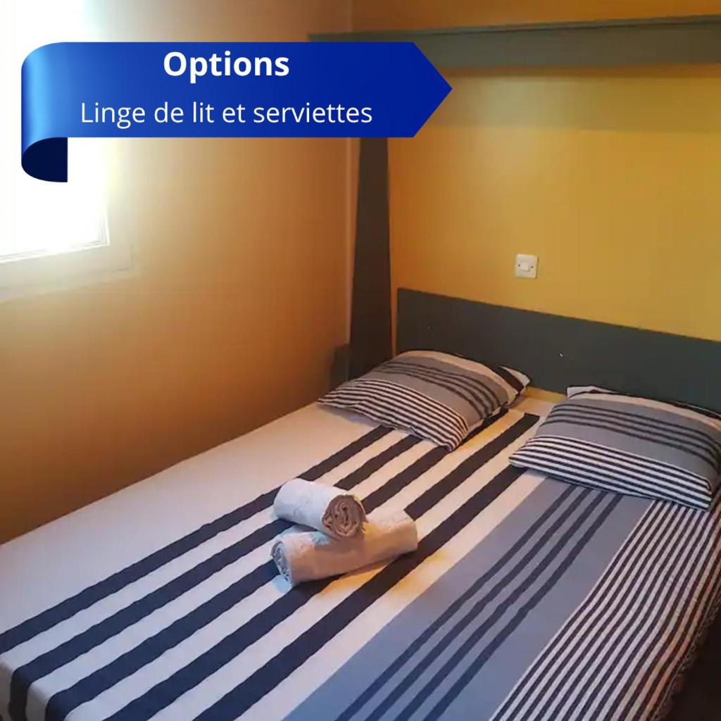 - un lit avec 2 serviettes pliantes dans l'établissement Cottage flottant terrasse jacuzzi option aux Portes de Dijon, à Ouges