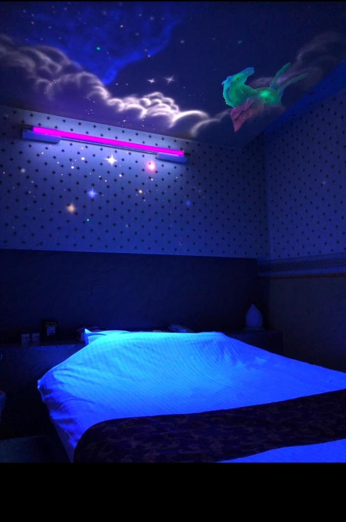 une chambre avec un lit avec une nuit étoilée dans l'établissement HOTEL Bew Rose Mary, à Kai