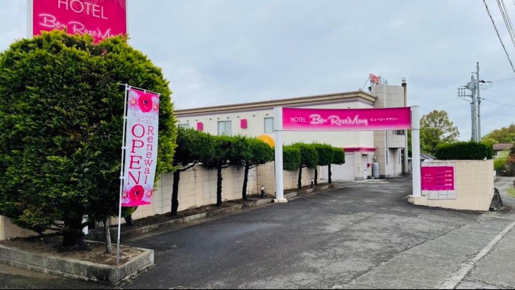 un hôtel avec des panneaux roses devant un bâtiment dans l'établissement HOTEL Bew Rose Mary, à Kai