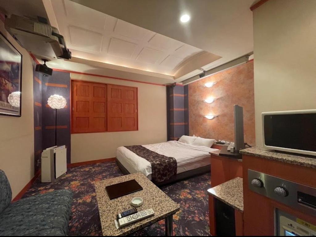 une chambre d'hôtel avec un lit et une télévision dans l'établissement HOTEL Bew Rose Mary, à Kai