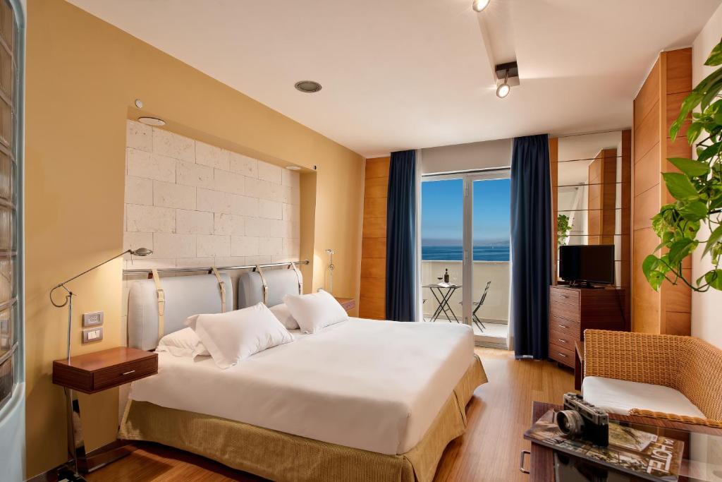 une chambre avec un lit avec vue sur l'océan dans l'établissement Towers Hotel Stabiae Sorrento Coast, à Castellammare di Stabia