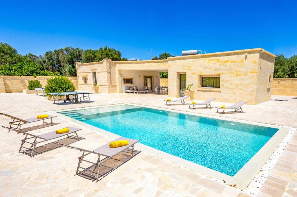 une villa avec piscine devant une maison dans l'établissement Villa Gea by Villa Plus, à Carovigno