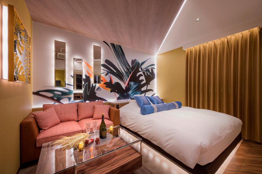 une chambre avec un lit et un canapé dans l'établissement ホテルLuce Regaloｰルーチェレガーロ, à Rifu