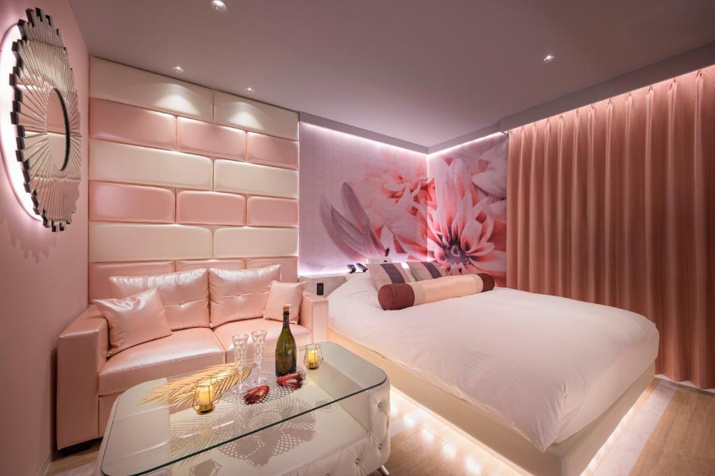 une chambre avec un lit, un canapé et une table dans l'établissement ホテルLuce Regaloｰルーチェレガーロ, à Rifu